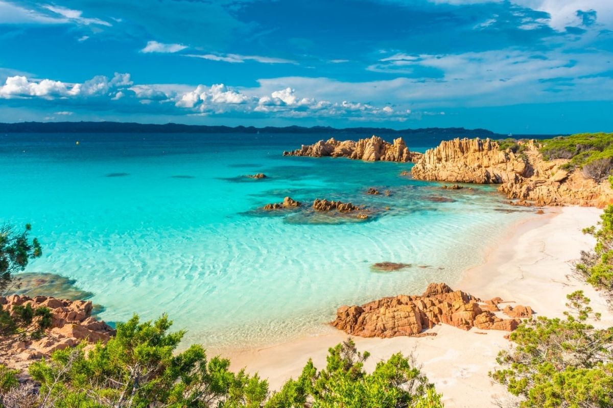 Spiaggia rosa di Budelli con acque turchesi e vegetazione mediterranea