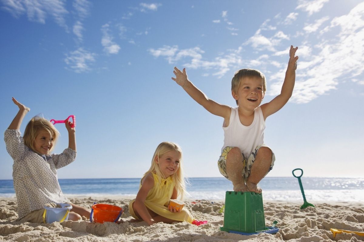 Panorama di Pula con famiglie che giocano sulla spiaggia