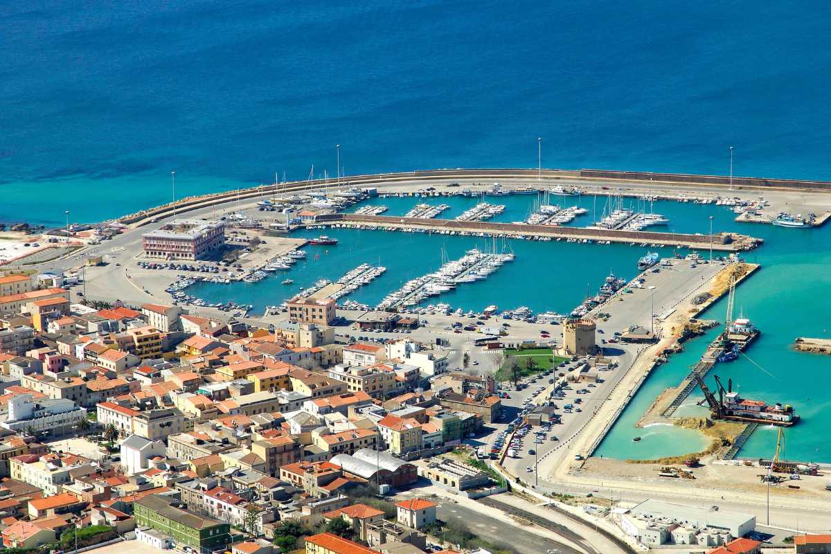 Vista panoramica di Porto Torres con bambini che giocano sulla spiaggia