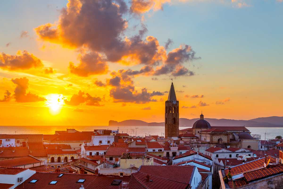 Vista panoramica dei bastioni di Alghero al tramonto, evidenziando l'atmosfera romantica