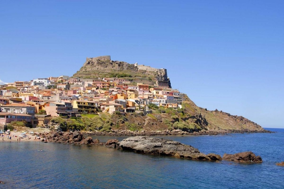 Spiaggia di Lu Bagnu con il mare cristallino e le montagne sullo sfondo